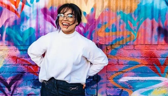 Woman standing in front of colourful background